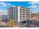 Modern apartment building featuring numerous balconies, landscaping, and covered parking at 1265 Race St # 203, Denver, CO 80206