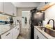 Efficient kitchenette with white cabinetry, stainless steel sink, and modern decor at 1265 Race St # 203, Denver, CO 80206