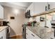 Kitchenette featuring modern appliances, white cabinetry, and a granite countertop at 1265 Race St # 203, Denver, CO 80206