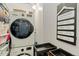 Functional laundry room with a stacked washer and dryer, shelving, and space-saving design at 1265 Race St # 203, Denver, CO 80206
