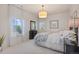 Bright bedroom with large windows, neutral walls and carpet, and classic black furniture at 10525 Sunshower Pl, Highlands Ranch, CO 80126