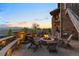 Stone fire pit with seating area surrounded by lush greenery, string lights, and scenic views at 10525 Sunshower Pl, Highlands Ranch, CO 80126