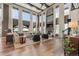 Light-filled living room with tall windows, stone fireplace, and hardwood floors at 10525 Sunshower Pl, Highlands Ranch, CO 80126