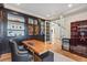 Executive office featuring custom cabinetry, glass doors, and a sleek desk at 10525 Sunshower Pl, Highlands Ranch, CO 80126