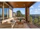 Covered patio with a stone pillar, comfortable seating, and a view of the backyard at 10525 Sunshower Pl, Highlands Ranch, CO 80126