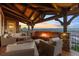 Covered outdoor patio with comfortable seating, a stone fireplace, and scenic views at 10525 Sunshower Pl, Highlands Ranch, CO 80126