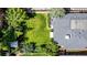 Aerial view of a green backyard with a patio and garden, complemented by a gray roof and mature trees at 1635 Poplar St, Denver, CO 80220
