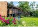 A backyard with vibrant pink peonies, a well-maintained lawn, and a covered patio with comfortable seating at 1635 Poplar St, Denver, CO 80220