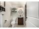 Well-lit bathroom with vanity, oval mirror, decorative shelving, and tiled shower at 1635 Poplar St, Denver, CO 80220