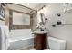 Bathroom with vanity, tile surround, tub, and decorative shelving at 1635 Poplar St, Denver, CO 80220