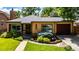 Charming brick home featuring a well-manicured lawn and colorful landscaping at 1635 Poplar St, Denver, CO 80220