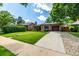 Well-kept brick home features an attached garage and a meticulously landscaped front yard at 1635 Poplar St, Denver, CO 80220