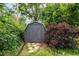 Backyard storage shed, surrounded by lush landscaping and stone pathway at 1635 Poplar St, Denver, CO 80220