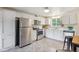 Updated kitchen with stainless steel appliances, ample white cabinetry, and a cozy breakfast bar at 5645 W 5Th Ave # 5645 & 5655, Lakewood, CO 80226