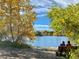 Scenic lake view with golden autumn trees and park bench, perfect for relaxation and enjoying nature's beauty at 5645 W 5Th Ave # 5645 & 5655, Lakewood, CO 80226