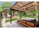 Backyard with a modern pergola, built-in seating, a covered grill, and a charming ivy-covered building at 1226 Dexter St, Denver, CO 80220
