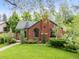Attractive brick home with a turret entry, arched windows, and a beautifully landscaped front yard at 1226 Dexter St, Denver, CO 80220
