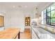 Open kitchen features white cabinets and stainless appliances with a butcher block island at 1226 Dexter St, Denver, CO 80220