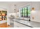 Bright kitchen with stainless steel appliances, white cabinets, subway tile backsplash and view of backyard at 1226 Dexter St, Denver, CO 80220
