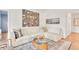 Bright living room featuring a large white sectional sofa, artistic wall decor, and hardwood floors at 1226 Dexter St, Denver, CO 80220