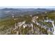 Expansive aerial view showcasing the tranquil mountain property and lush evergreen landscape at 10747 Timothys Dr, Conifer, CO 80433