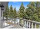 Balcony view showing tall pine trees in a mountain area with snowy patches on the ground at 10747 Timothys Dr, Conifer, CO 80433