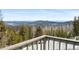 Balcony view showing distant mountains and pine trees, providing a sense of serenity and natural beauty at 10747 Timothys Dr, Conifer, CO 80433
