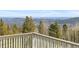 Balcony view showing distant mountains and pine trees, providing a sense of serenity and natural beauty at 10747 Timothys Dr, Conifer, CO 80433