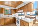 Well-lit kitchen with wood cabinets, white countertops, and scenic window views at 10747 Timothys Dr, Conifer, CO 80433
