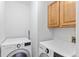 Functional laundry room featuring a modern washer, dryer, and ample storage cabinets at 10747 Timothys Dr, Conifer, CO 80433