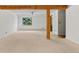 Spacious living room featuring a ceiling fan, natural light, and rustic wood beam support at 10747 Timothys Dr, Conifer, CO 80433