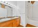 Bathroom featuring a dual sink vanity with wood cabinets and a shower-tub combo at 1745 Wazee St # 2B, Denver, CO 80202