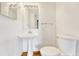 Compact half bath with sleek pedestal sink, modern fixtures, and tiled floors at 1745 Wazee St # 2B, Denver, CO 80202
