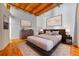 Bedroom featuring exposed beam ceiling, wood floors, neutral paint, and stylish furnishings at 1745 Wazee St # 2B, Denver, CO 80202