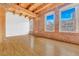 Spacious room featuring exposed brick walls, hardwood floors, and ample natural light from large windows at 1745 Wazee St # 2B, Denver, CO 80202