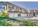 Exterior angle view of garages of the townhome with lush green landscaping on a sunny day at 5950 Gunbarrel Ave # F, Boulder, CO 80301