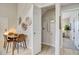 Hallway with dining table, laundry closet, and an open bedroom doorway with large plant and window at 5950 Gunbarrel Ave # F, Boulder, CO 80301