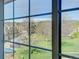 Scenic view through a large window showcasing lush greenery, neighboring townhomes, and distant mountains under a blue sky at 5950 Gunbarrel Ave # F, Boulder, CO 80301