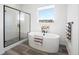 Bright bathroom featuring a standalone tub, walk-in shower, and a view from the window at 5681 Water Avens Dr, Castle Rock, CO 80104