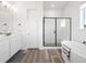 A modern bathroom with a walk-in shower, stand alone tub and wood grain tile at 5681 Water Avens Dr, Castle Rock, CO 80104