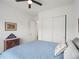 Cozy bedroom with blue bedspread, white walls, ceiling fan, and closet space at 5681 Water Avens Dr, Castle Rock, CO 80104