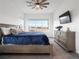 Bright bedroom with a large window, ceiling fan, and an elegant blue bedspread at 5681 Water Avens Dr, Castle Rock, CO 80104