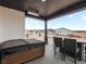Covered patio with hot tub, outdoor table and chairs, with neighborhood view at 5681 Water Avens Dr, Castle Rock, CO 80104