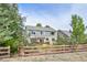 Fenced backyard view of home with a deck, garden, and trees; perfect for outdoor living and privacy at 5686 Brook Hollow Dr, Broomfield, CO 80020