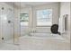 Bright bathroom with soaking tub, glass shower, and natural light from the window at 5686 Brook Hollow Dr, Broomfield, CO 80020