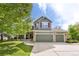 Charming two-story home featuring a three-car garage and beautifully landscaped front yard with mature trees at 5686 Brook Hollow Dr, Broomfield, CO 80020