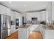 Bright kitchen featuring white cabinetry, stainless steel appliances, granite countertops, and hardwood flooring at 5686 Brook Hollow Dr, Broomfield, CO 80020