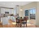 Bright kitchen with a breakfast nook featuring white cabinets, granite countertops, and a sliding glass door to deck at 5686 Brook Hollow Dr, Broomfield, CO 80020