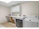 Functional laundry room with front load washer and dryer, storage cabinets, and a sink at 5686 Brook Hollow Dr, Broomfield, CO 80020
