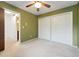 This bedroom showcasing olive walls, plush carpet, and a spacious closet at 1765 S Kline Way, Lakewood, CO 80232